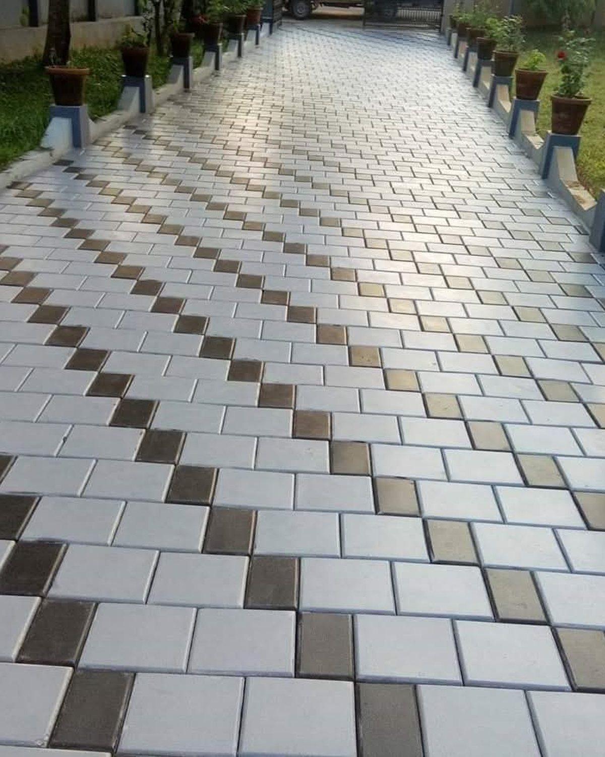 Allée de villa bordée de jardinières, pavés carrés posés en damier