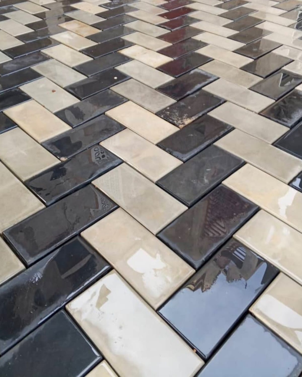 Terrasse en pavé chevron à finition brillante, noir et beige